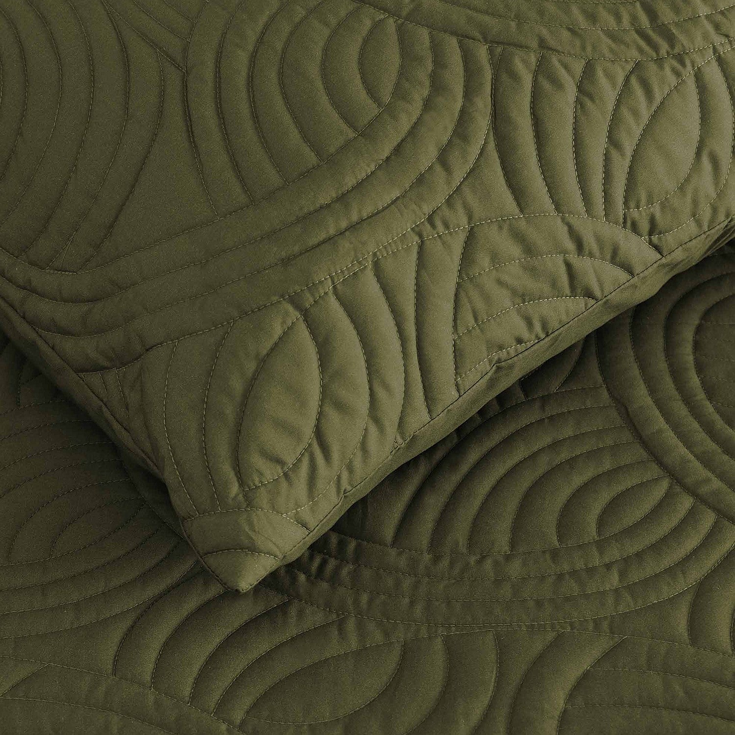 Olive green quilted coverlet close-up showing textured stitched pattern and matching pillowcase.