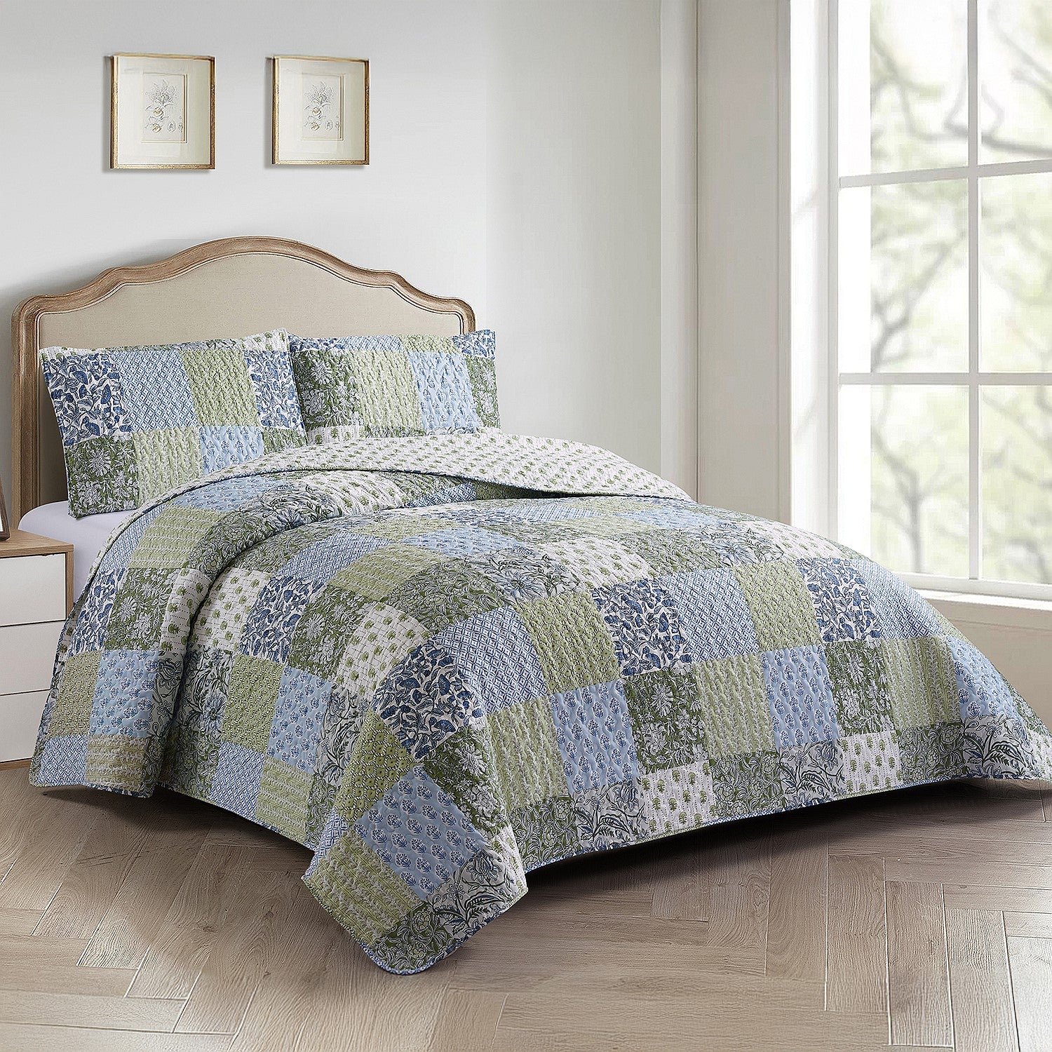 Patchwork coverlet set in blue, green and grey tones styled on a bed with matching pillowcases in a neutral bedroom.