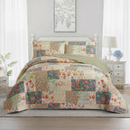 Multicoloured patchwork coverlet set styled on a bed with matching pillowcases in a bright bedroom.