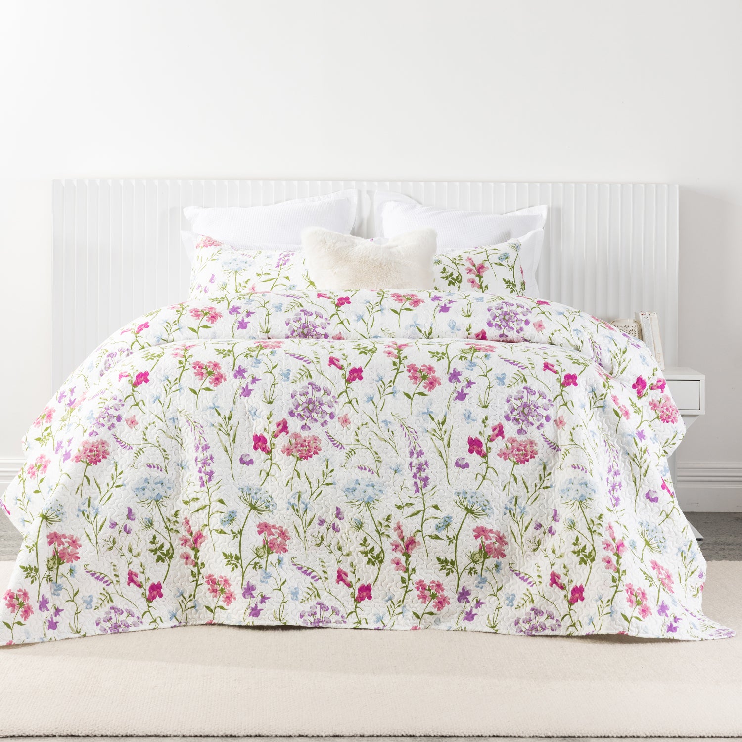 A delicate wildflower coverlet set in soft pink, lilac, blue and green tones brings a fresh garden-inspired charm to the bedroom with its light, airy floral design.