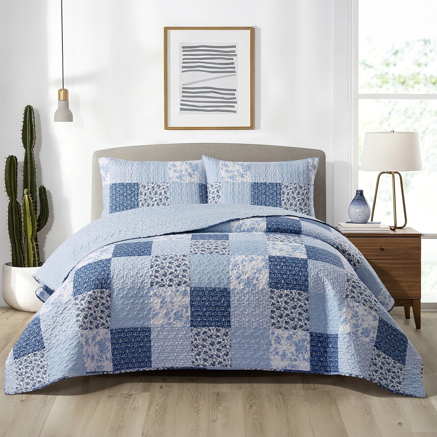 Home Co. Jax Patchwork Coverlet Set in Blue, styled on a bed with coordinating patchwork pillow shams in a bright contemporary bedroom.