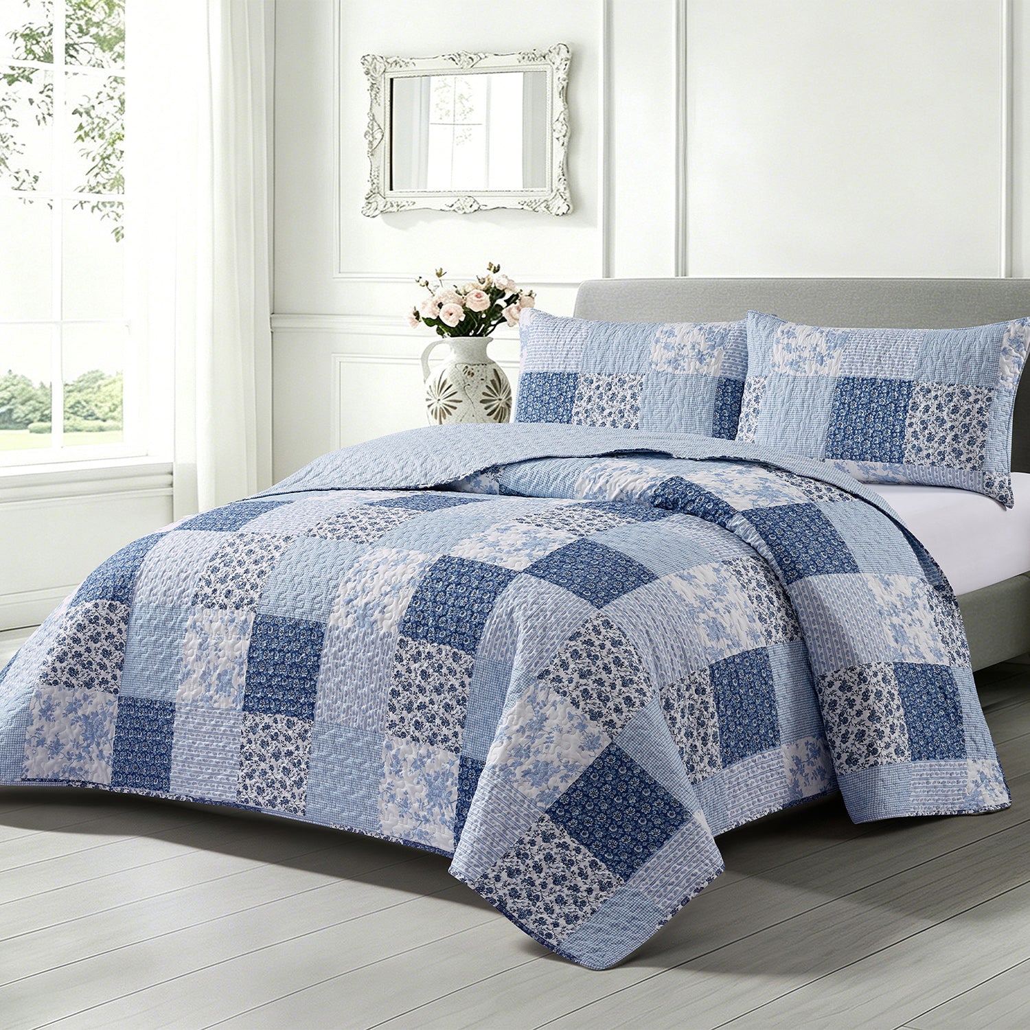 Home Co. Jax Patchwork Coverlet Set in Blue, styled on a bed with coordinating patchwork pillow shams in a bright contemporary bedroom.