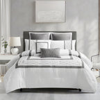 White and grey geometric comforter set styled on a bed with matching pillows in a modern bedroom.