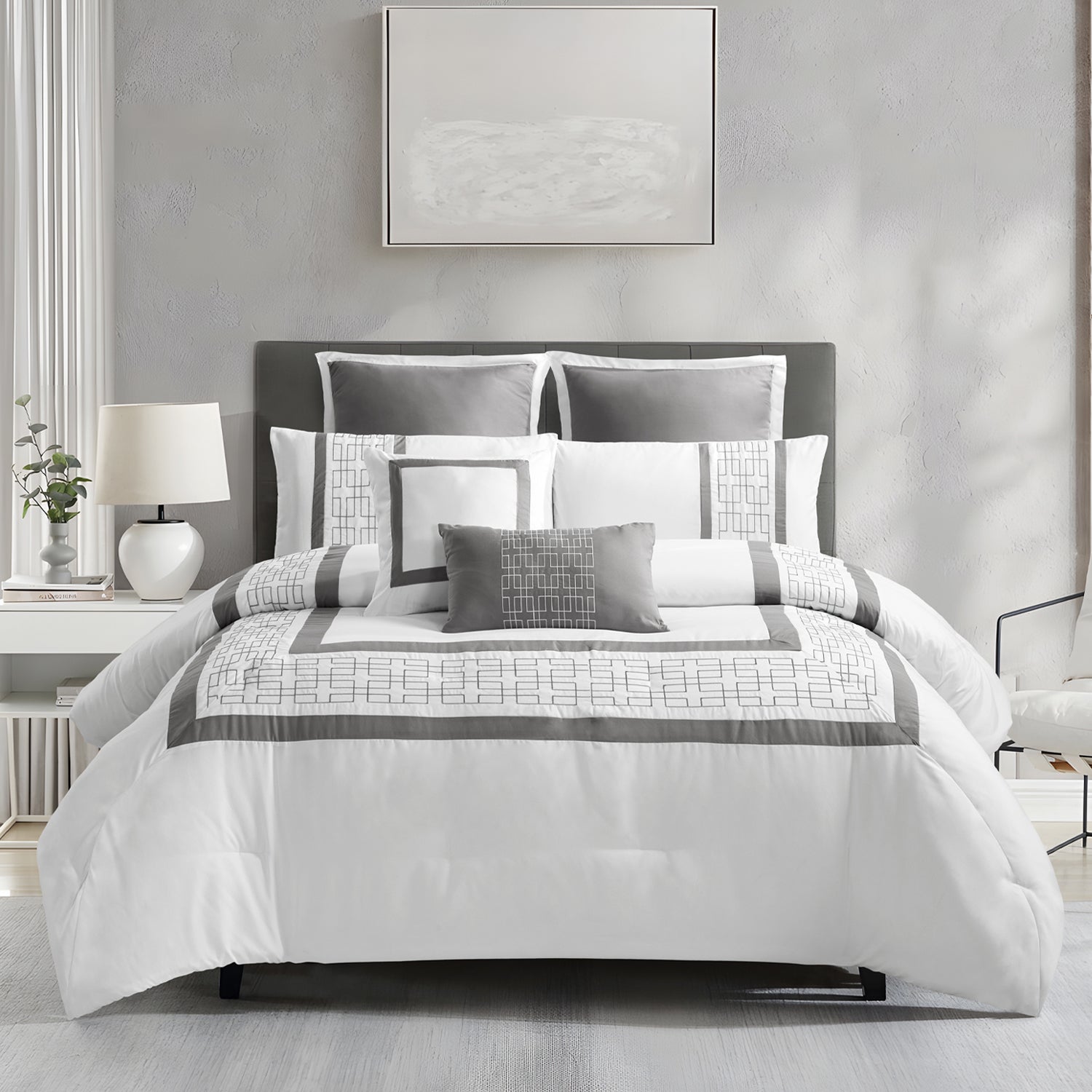 White and grey geometric comforter set styled on a bed with matching pillows in a modern bedroom.
