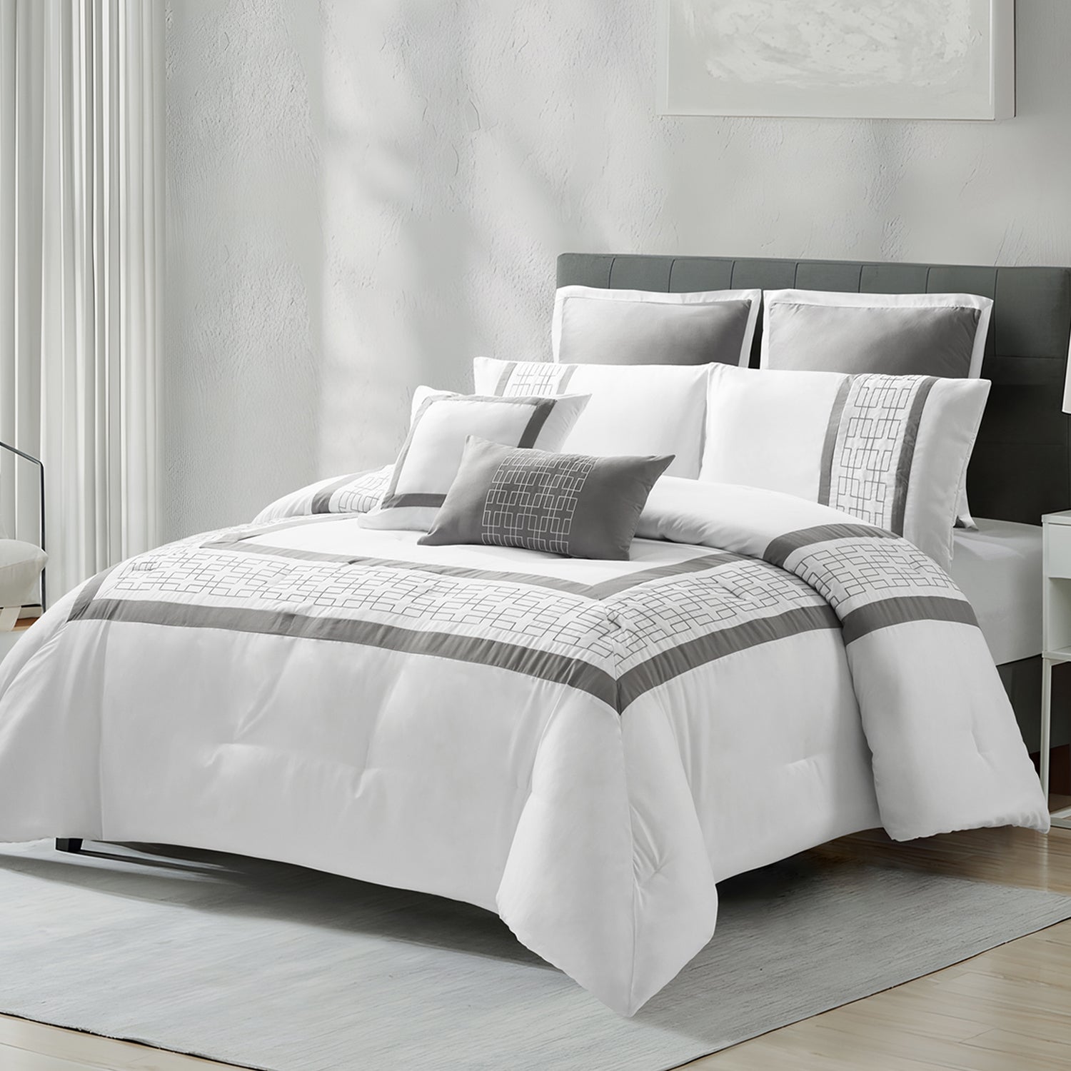 White and grey geometric comforter set styled on a bed with matching pillows in a modern bedroom.