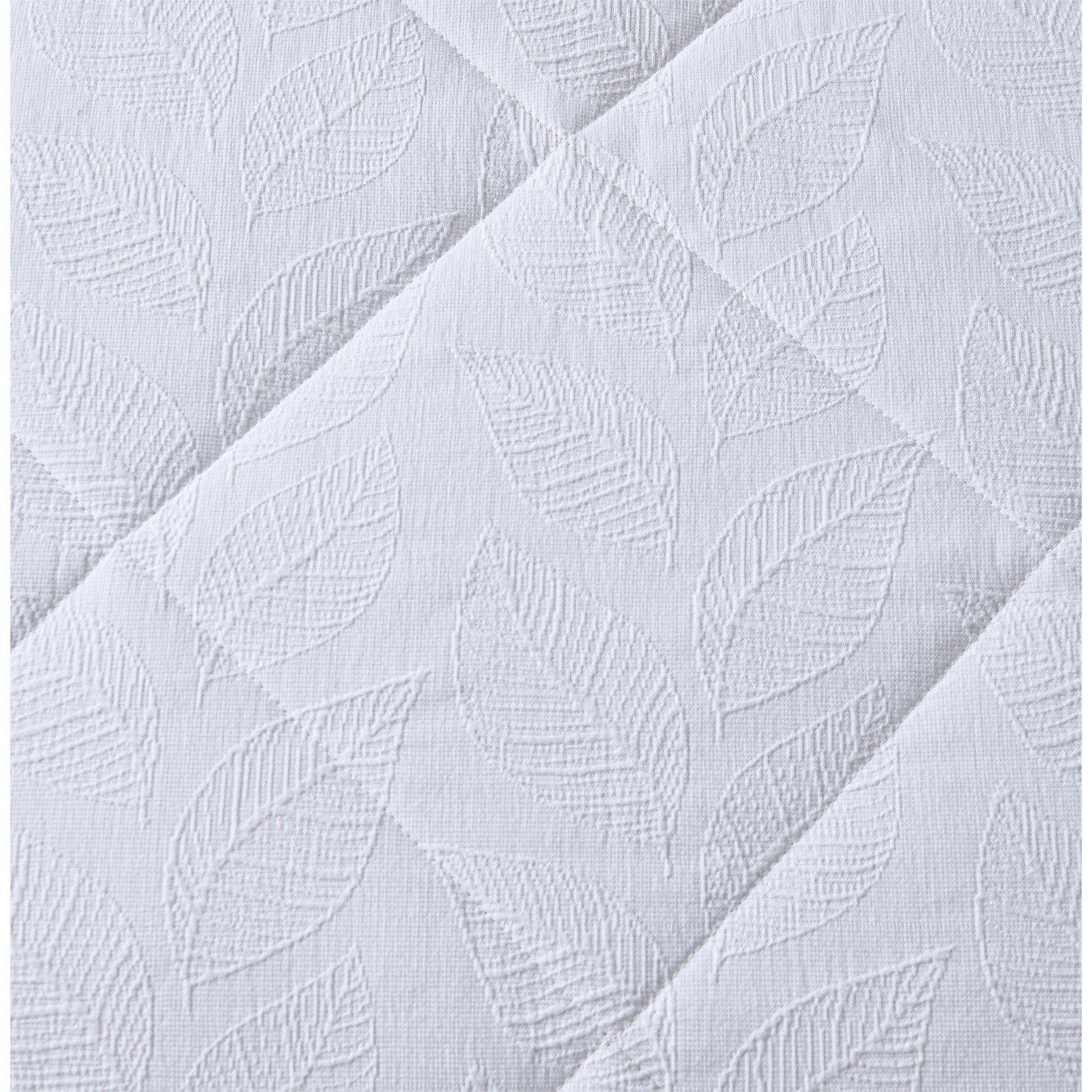 White quilted coverlet close-up showing soft textured fabric and stitched detail