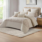 Neutral comforter set styled on a bed with matching pillows and a decorative throw in a bright bedroom.