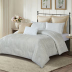 White textured comforter set styled on a bed with matching pillows in a neutral bedroom.