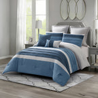 Blue striped comforter set styled on a bed with matching pillows in a bright modern bedroom.