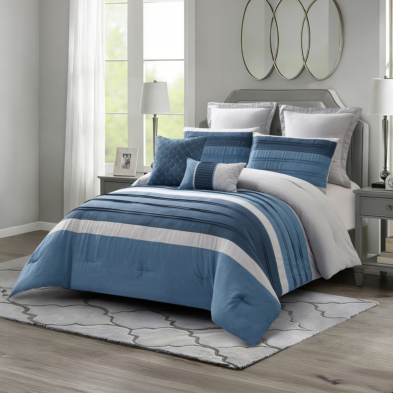 Blue striped comforter set styled on a bed with matching pillows in a bright modern bedroom.