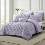 Angled view of the lilac seersucker comforter set on a neatly styled bed, highlighting the raised textured finish and coordinating cushions.
