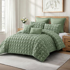 Angled view of the chive green seersucker comforter set on a styled bed, showing the soft gathered texture and coordinating green cushions.