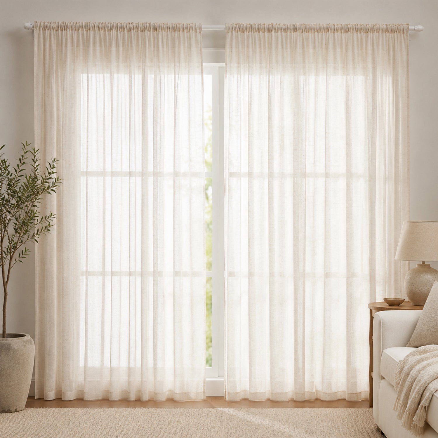 Soft natural sheer curtains with a pencil pleat header gently filter daylight, creating a warm, airy, and inviting living space.