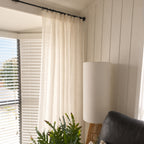 A soft natural sheer curtain with a pencil pleat header adds warmth and gently filters sunlight, creating a light and inviting living space.