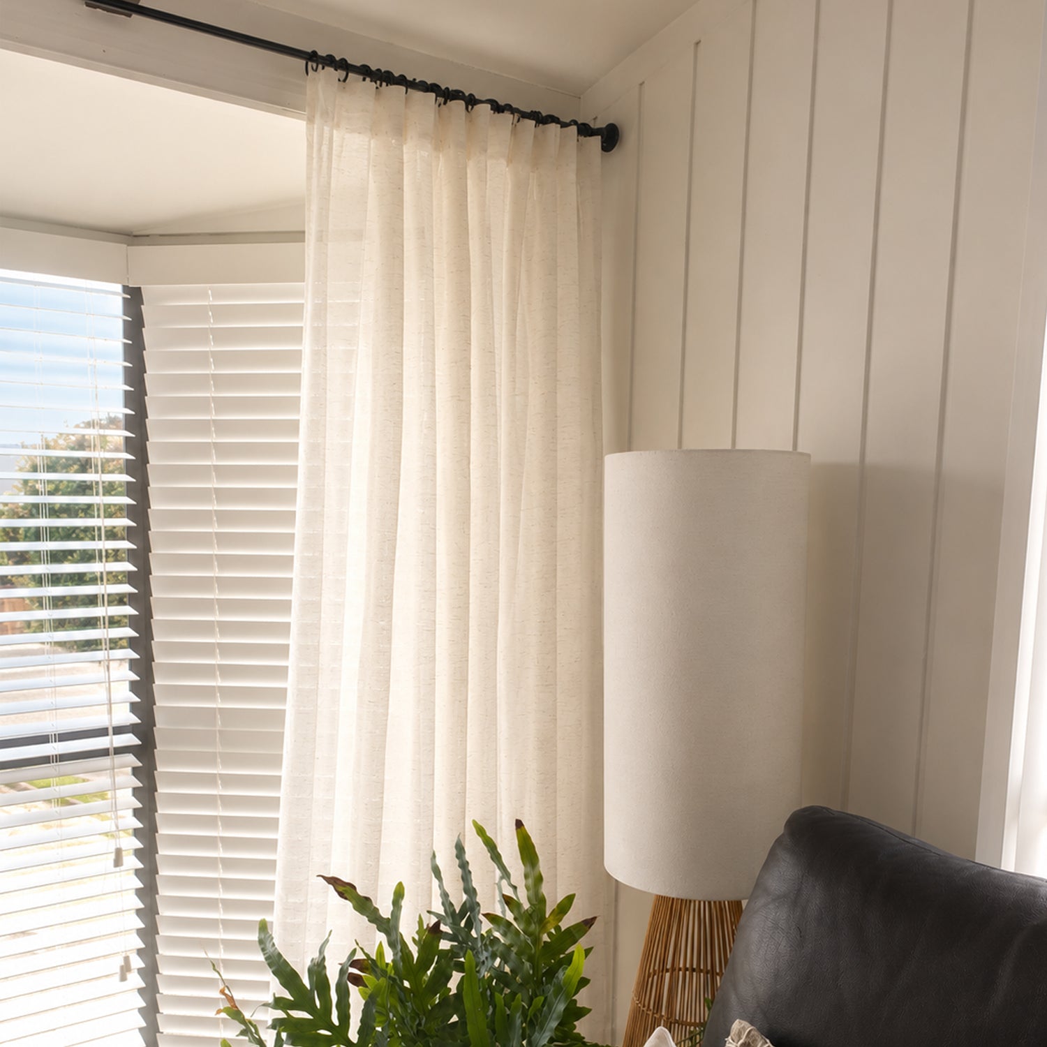 A soft natural sheer curtain with a pencil pleat header adds warmth and gently filters sunlight, creating a light and inviting living space.