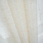 A close-up of an linen sheer curtain showcases its softly textured woven fabric and elegant drape as it gently filters natural light.