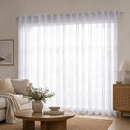 Soft white sheer eyelet curtains gently diffuse natural light, creating a bright, airy, and effortlessly elegant living space.