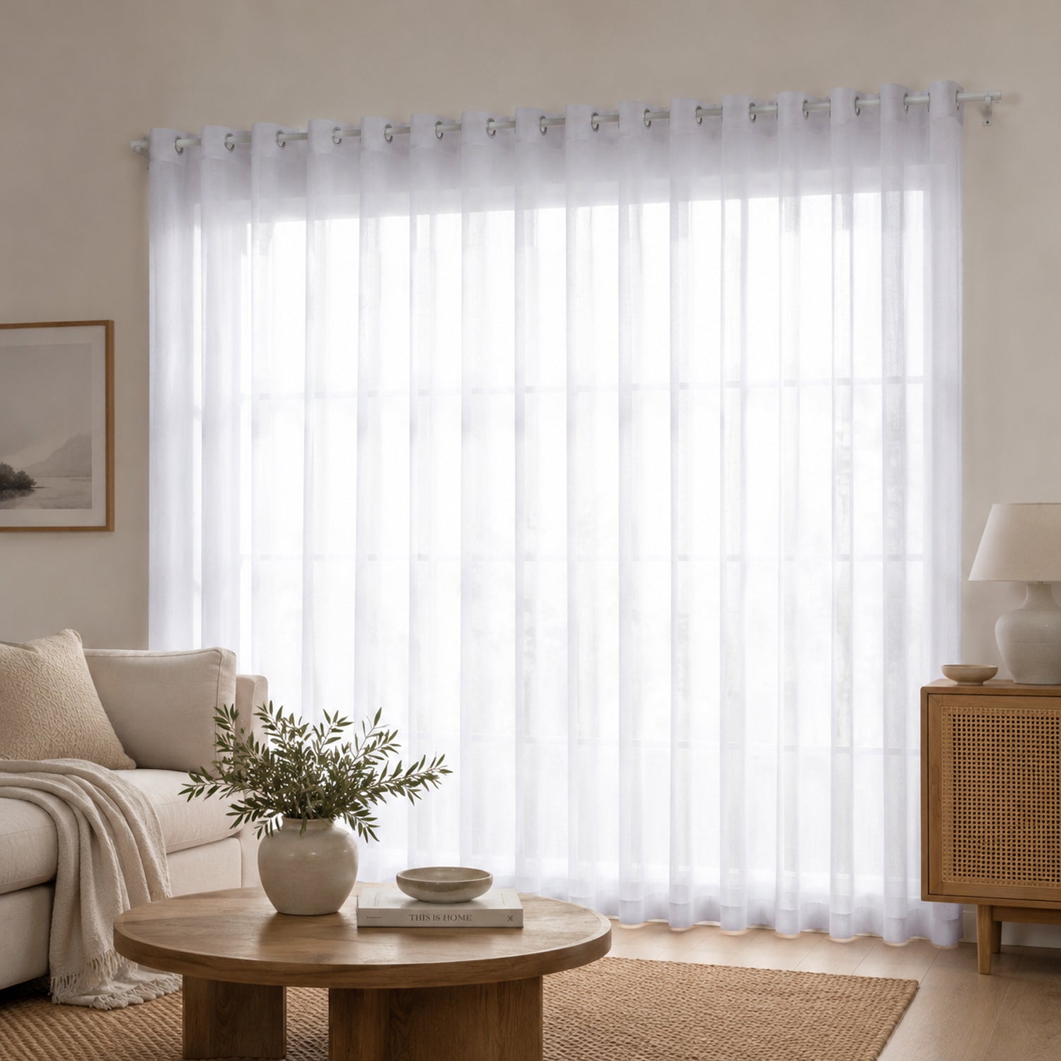 Soft white sheer eyelet curtains gently diffuse natural light, creating a bright, airy, and effortlessly elegant living space.