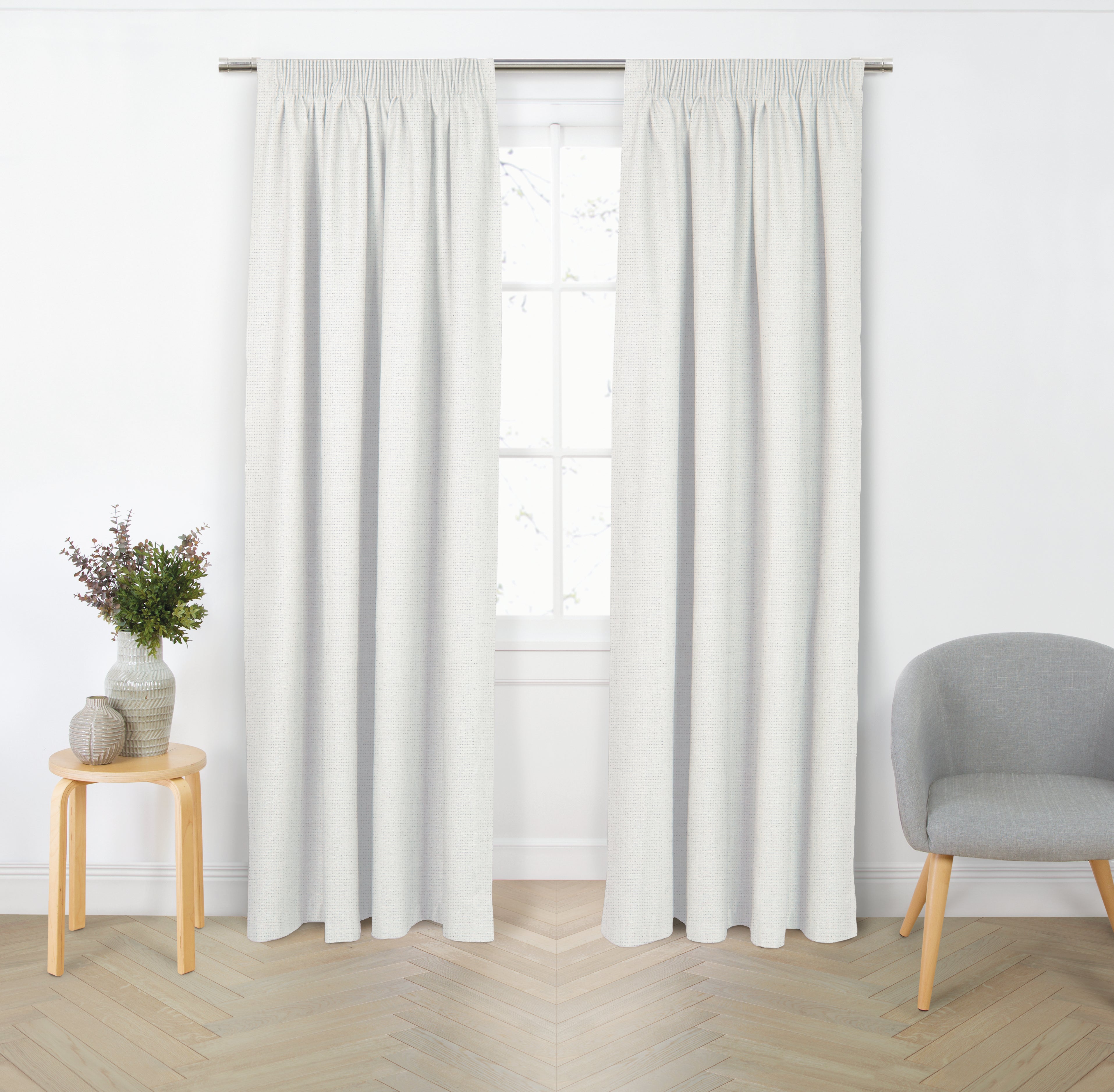 Whisper white blockout curtain pair with gathered header displayed in a bright modern living room.