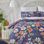Floral bedding set on a bed with a white headboard and decorative plants.