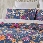 Floral bedding set on a bed with a white headboard.