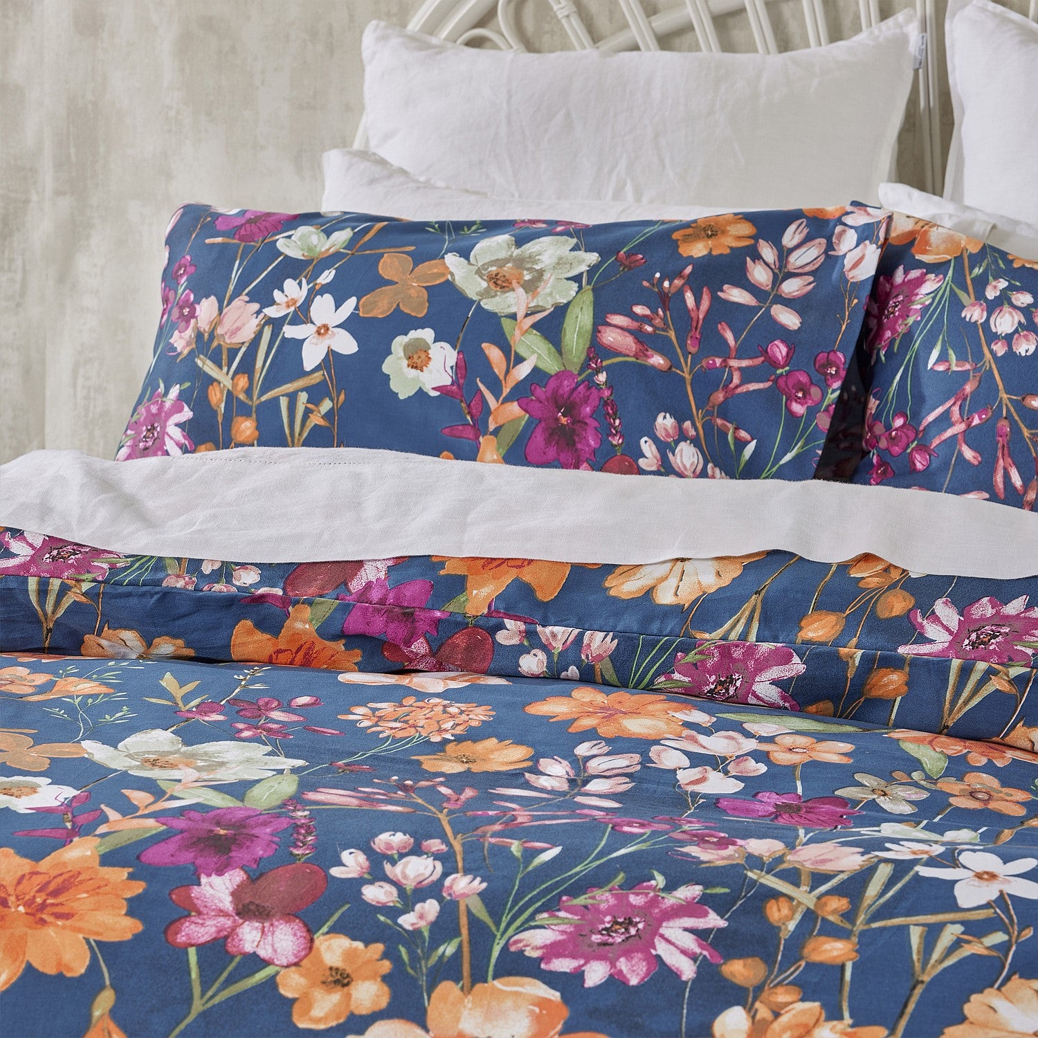 Floral bedding set on a bed with a white headboard.