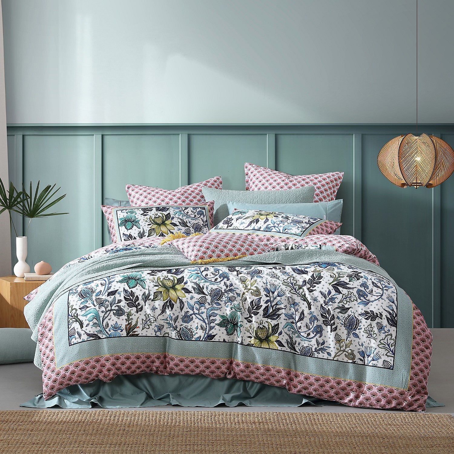 Floral bedding set on a bed with a green headboard and decorative elements.