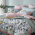 Floral patterned bedding set on a bed with decorative pillows.
