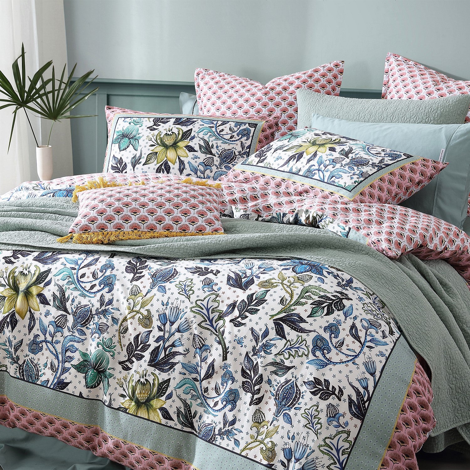 Floral patterned bedding set on a bed with decorative pillows.