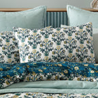 Floral patterned pillows on a bed with a neutral background