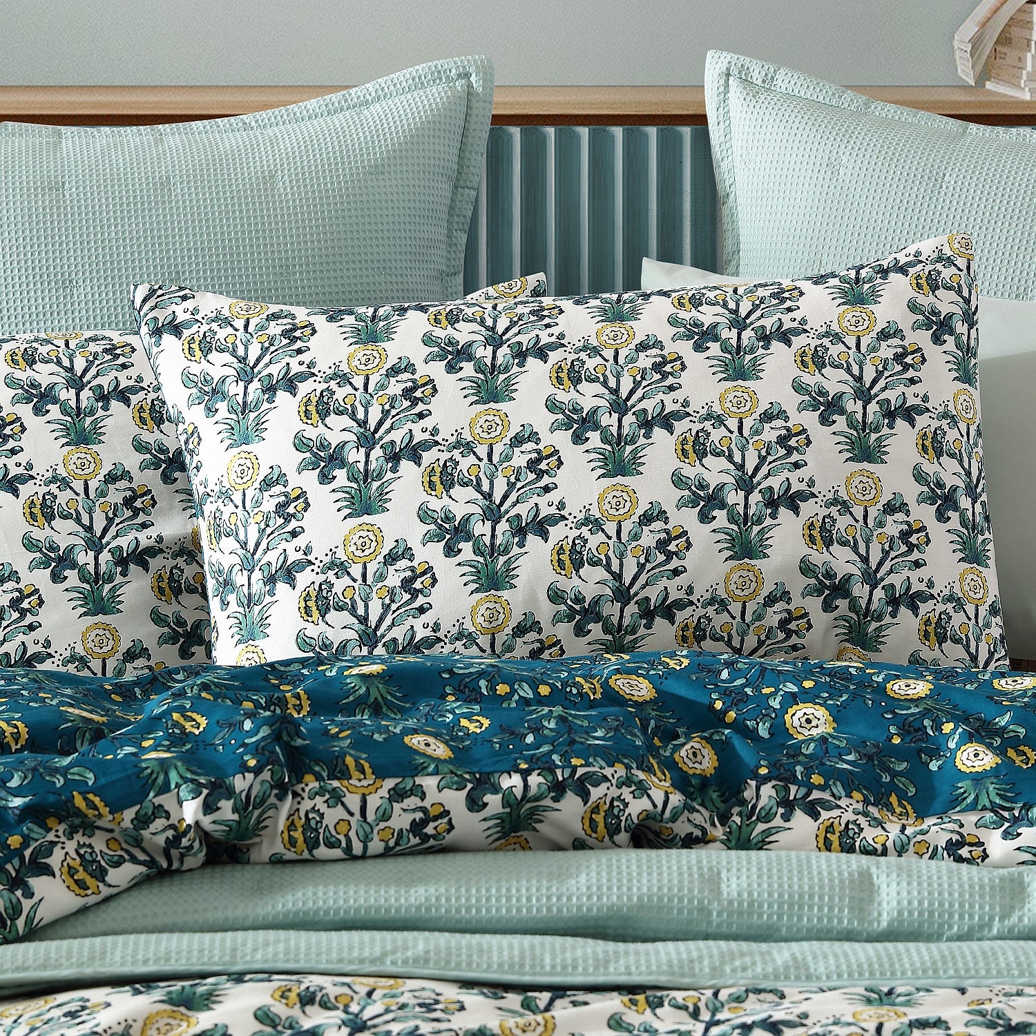 Floral patterned pillows on a bed with a neutral background