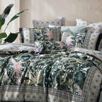 Decorative bedspread with tropical leaf pattern on a bed with matching pillows.