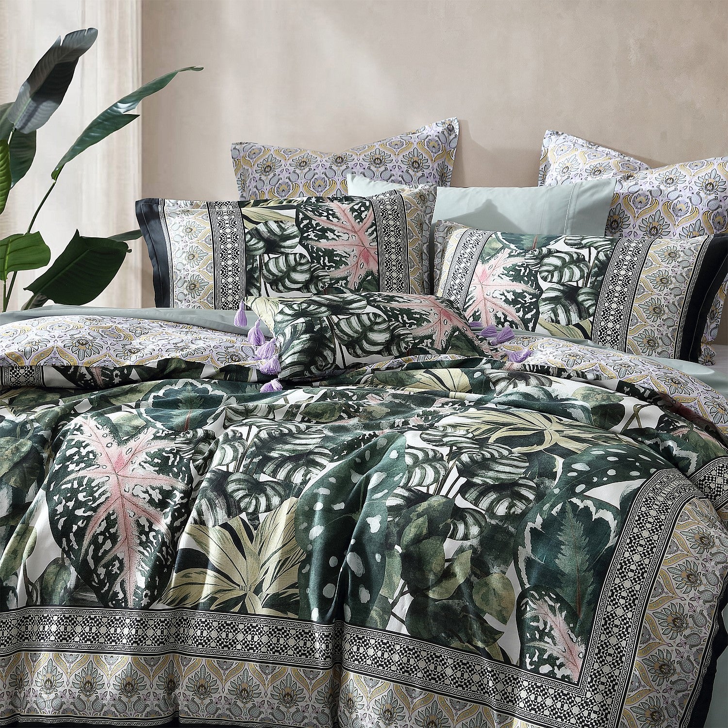 Decorative bedspread with tropical leaf pattern on a bed with matching pillows.