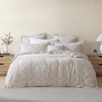 Neatly made bed with patterned bedding in a bedroom setting.