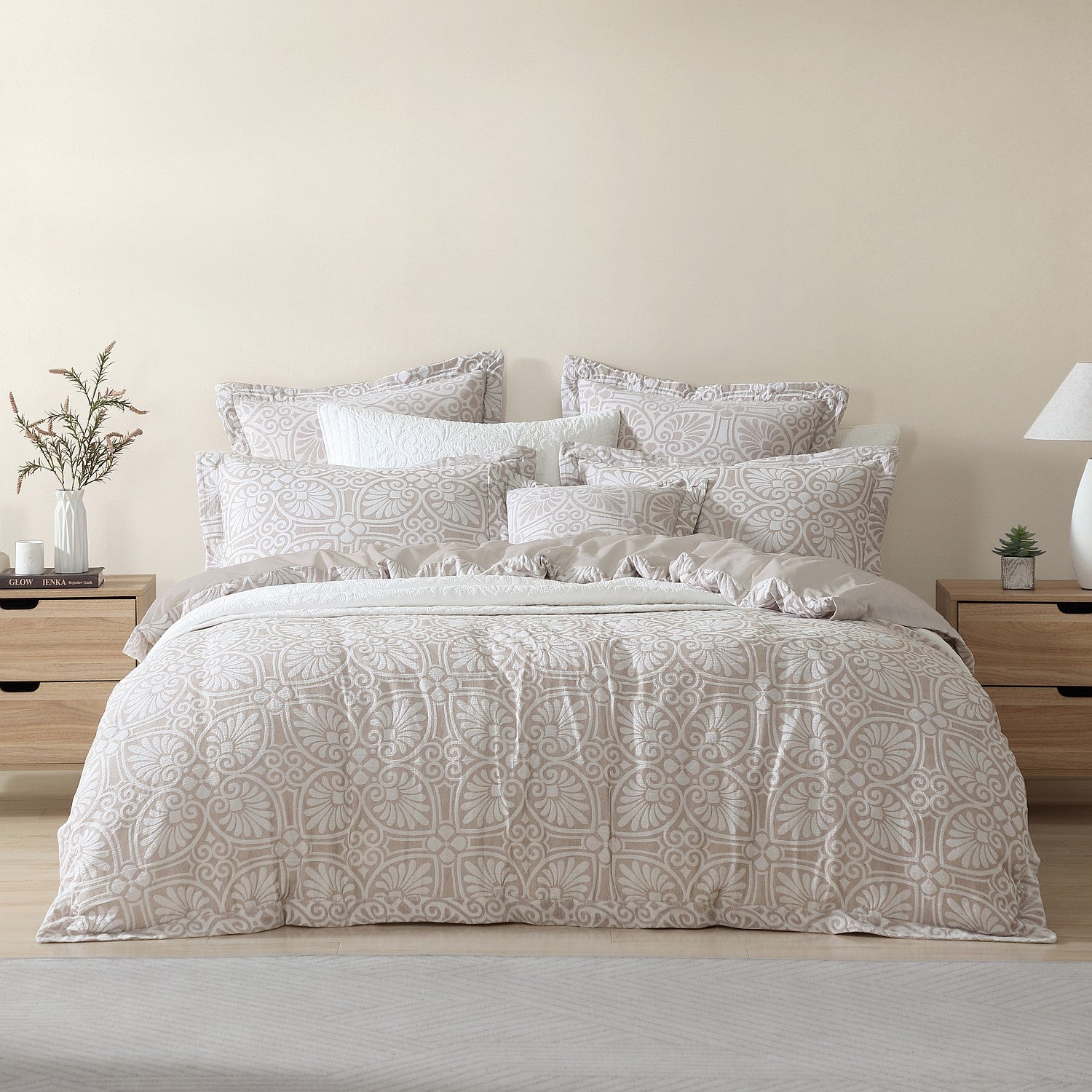 Neatly made bed with patterned bedding in a bedroom setting.