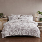 Floral patterned bedding set on a bed in a bedroom setting with side tables and decor.