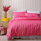 Bed with pink and yellow striped bedding in a bedroom setting.