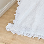 White eyelet lace tablecloth on a wooden floor