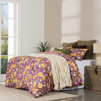 Bedroom with floral comforter and pillows near a window