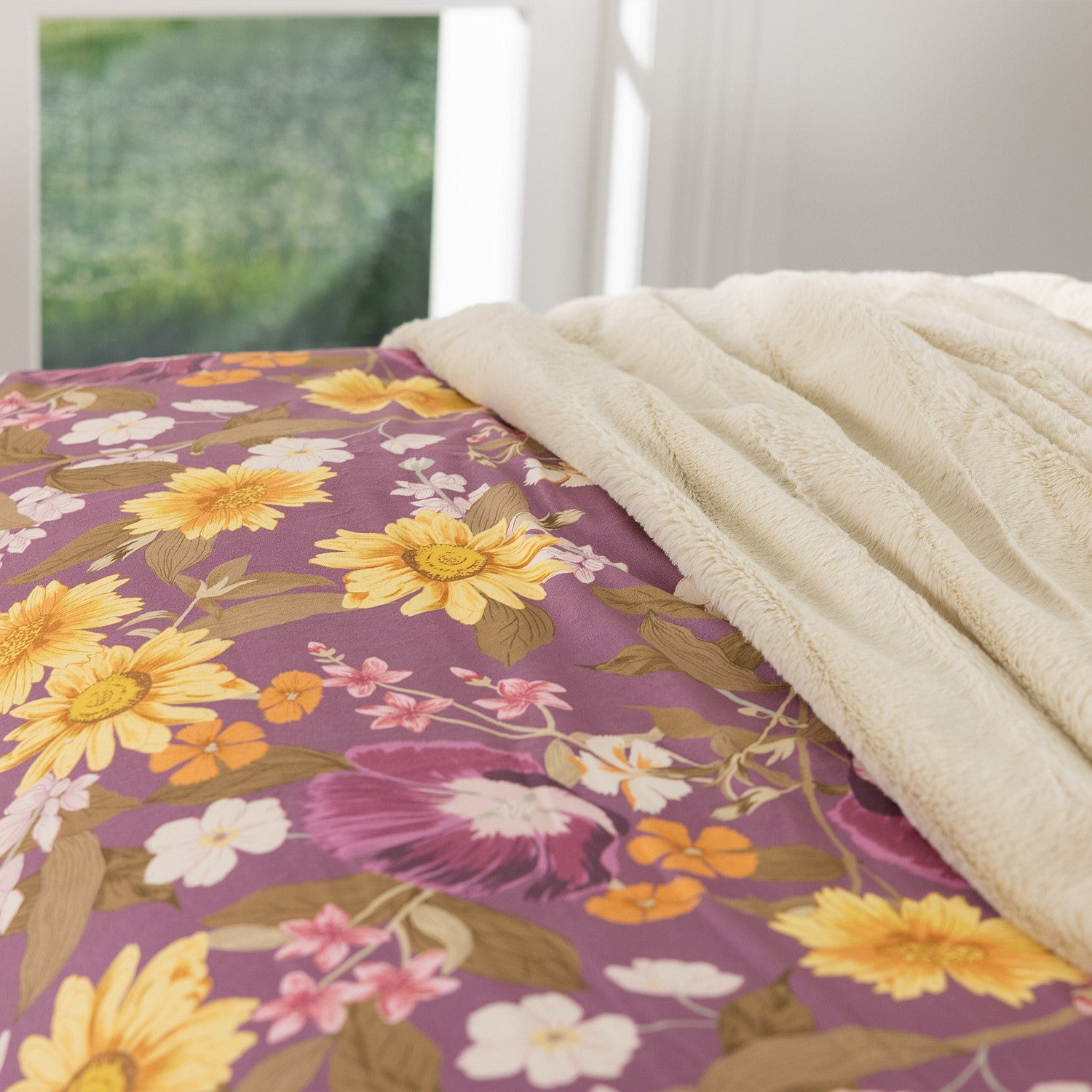 Floral patterned comforter on a bed with a white blanket
