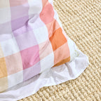 Colorful checkered blanket on a textured beige surface