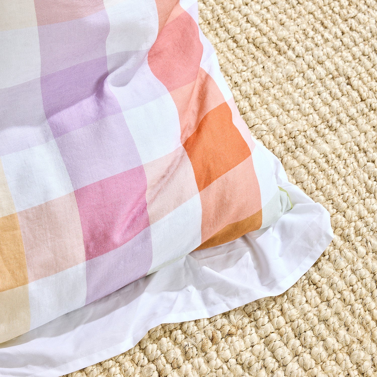 Colorful checkered blanket on a textured beige surface