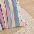 Close-up of a striped fabric pillow on a textured surface