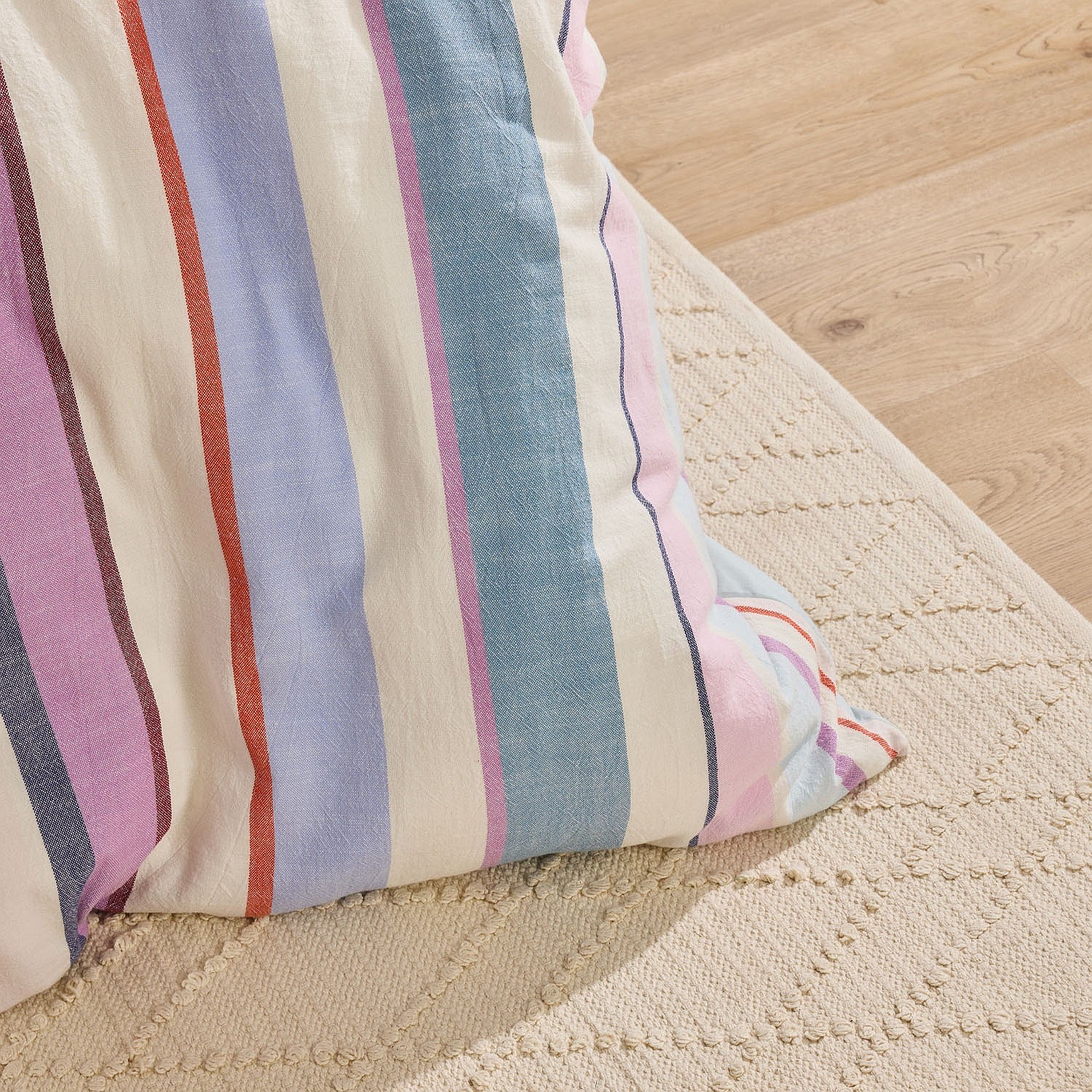 Close-up of a striped fabric pillow on a textured surface