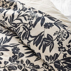 Floral patterned fabric with black leaves and flowers on a white background