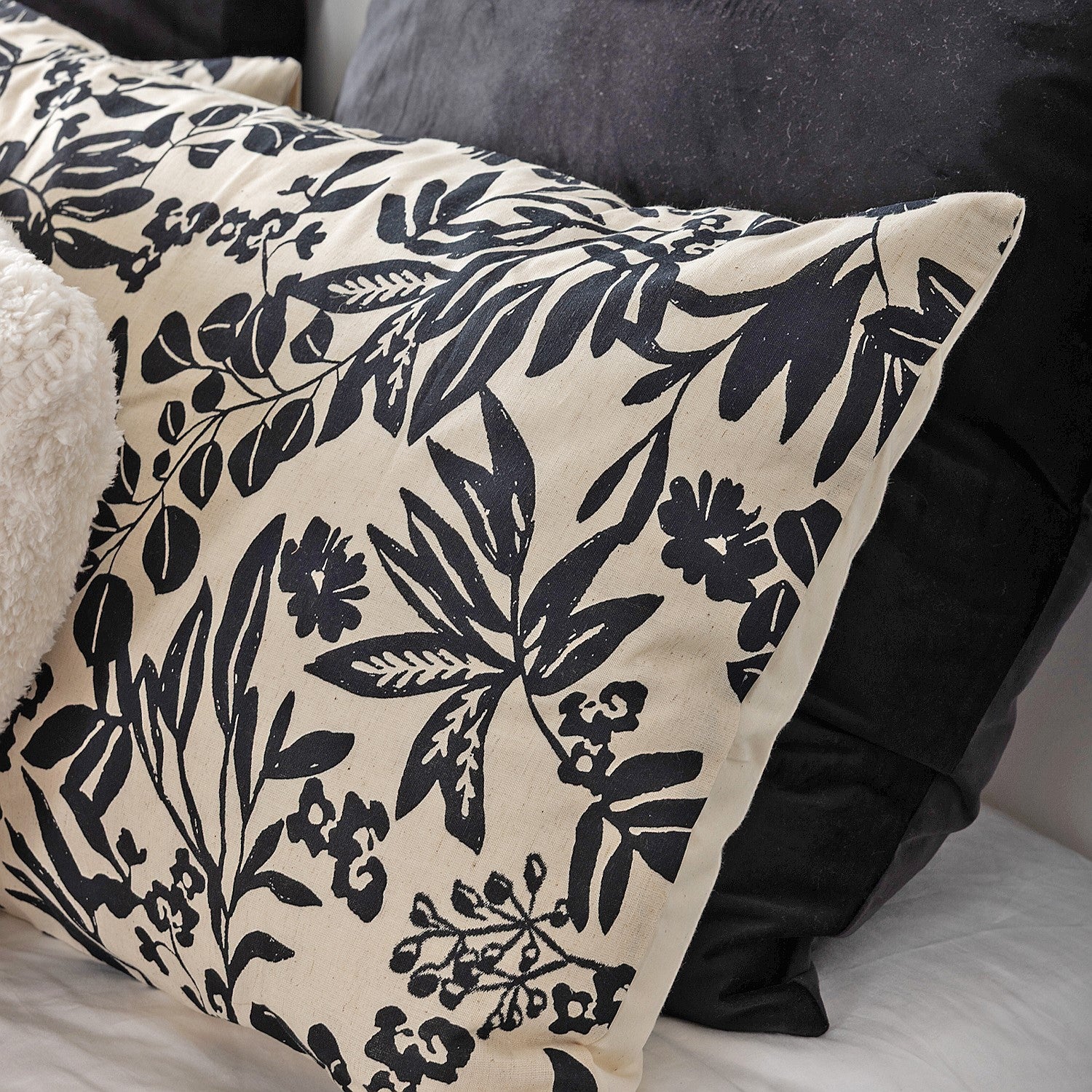Floral patterned pillow with black design on beige background