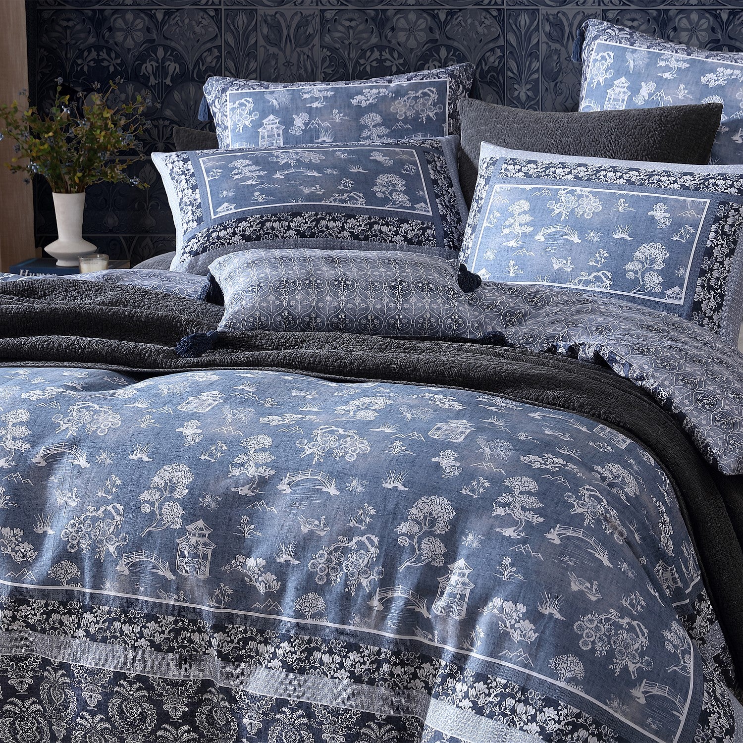 Decorative bedspread with floral patterns on a bed in a room setting.