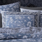 Set of blue patterned pillows and bedspread on a dark background