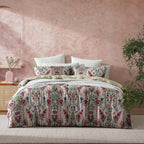 Bed with patterned bedding against a pink wall
