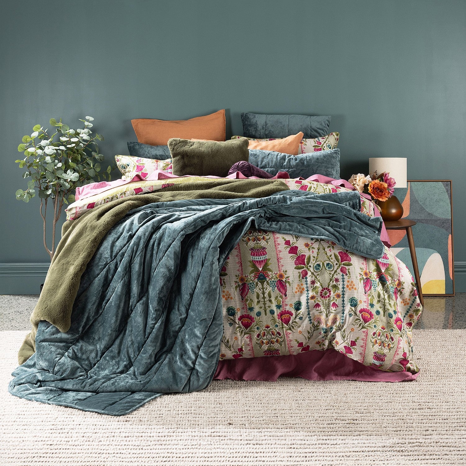 Colorful bedding set on a bed with a decorative headboard against a dark green wall.
